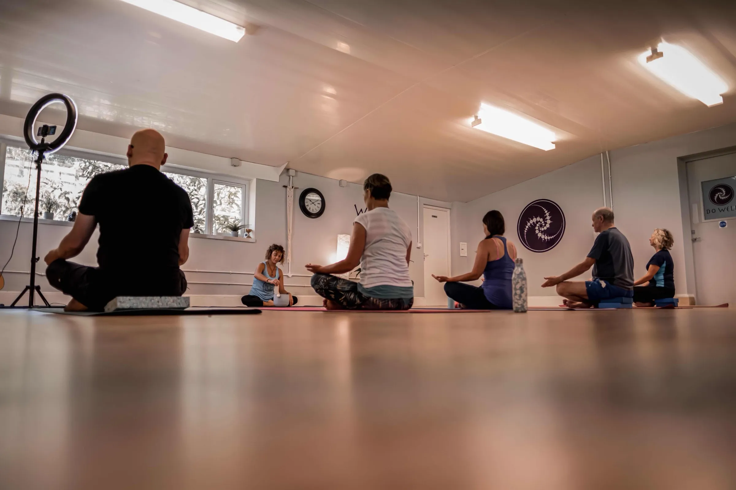 A class sitting cross-legged on their mats