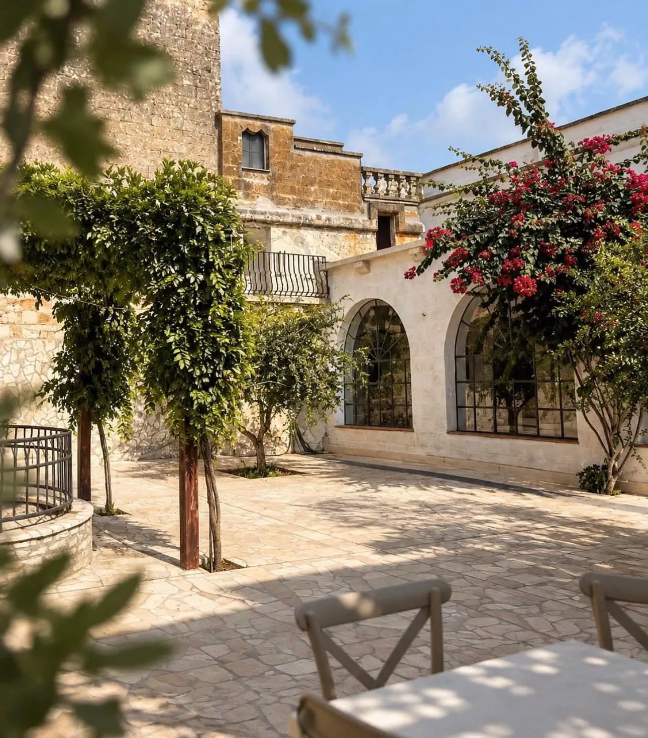 A shady, vine-covered stone courtyard at the masseria, with tables set out