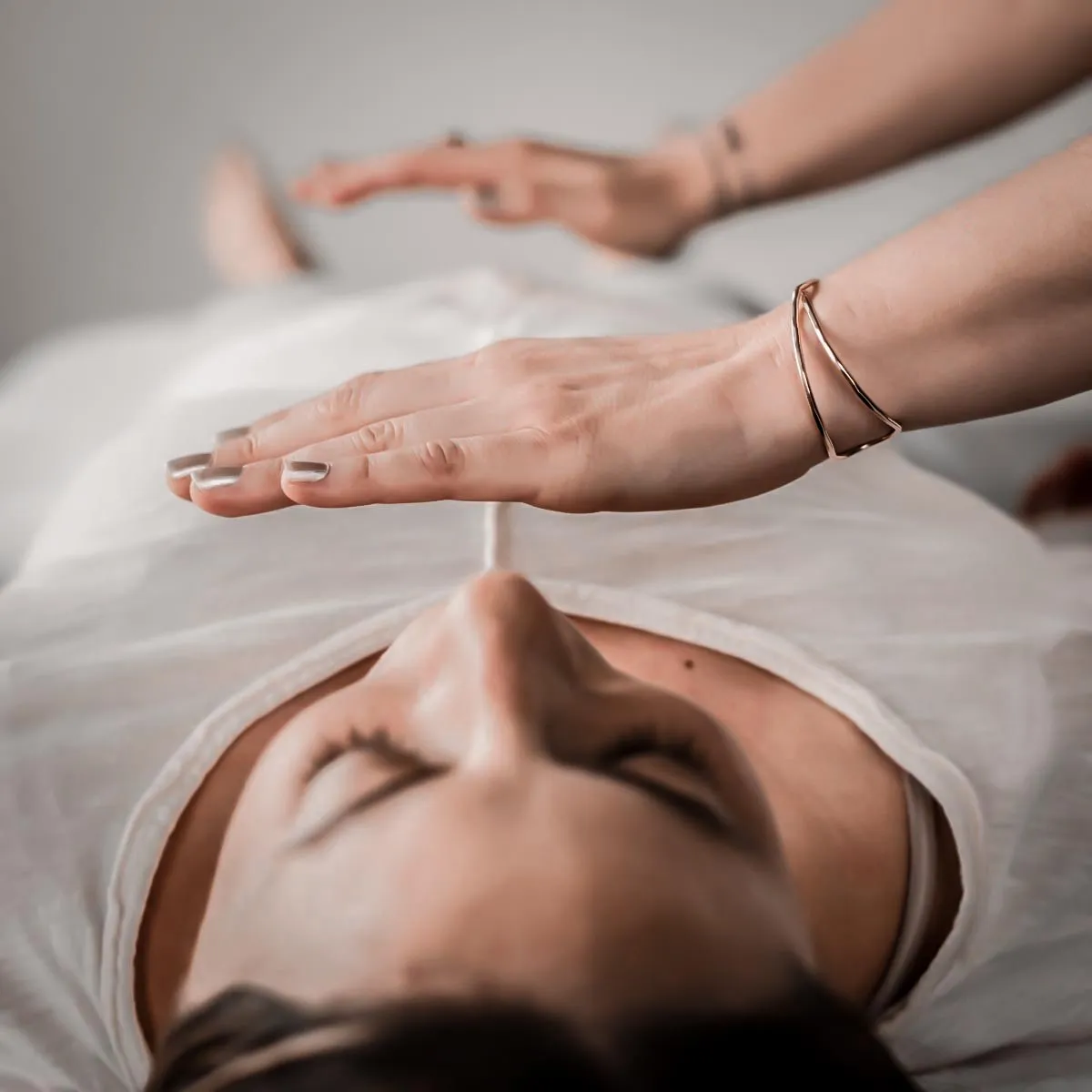 Mirella giving Reiki, her hands held above a client