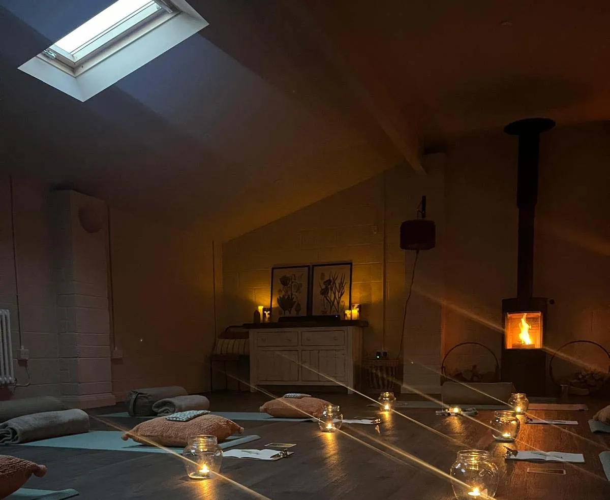 The candlelit yoga room with a wood burner at The Old Rectory