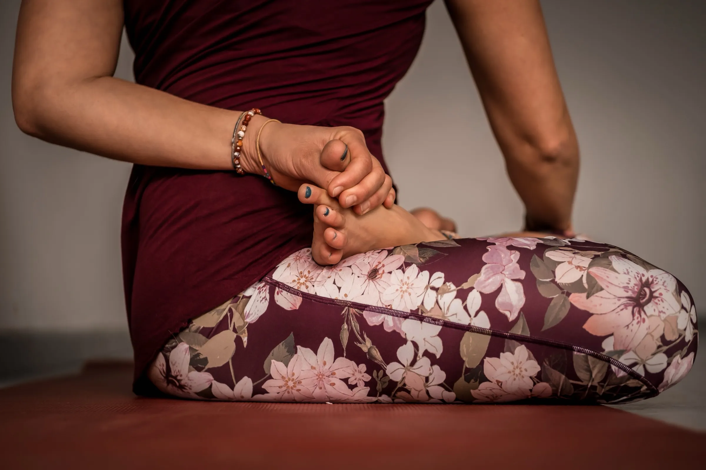 Close-up of a student holding their foot in a seated pose